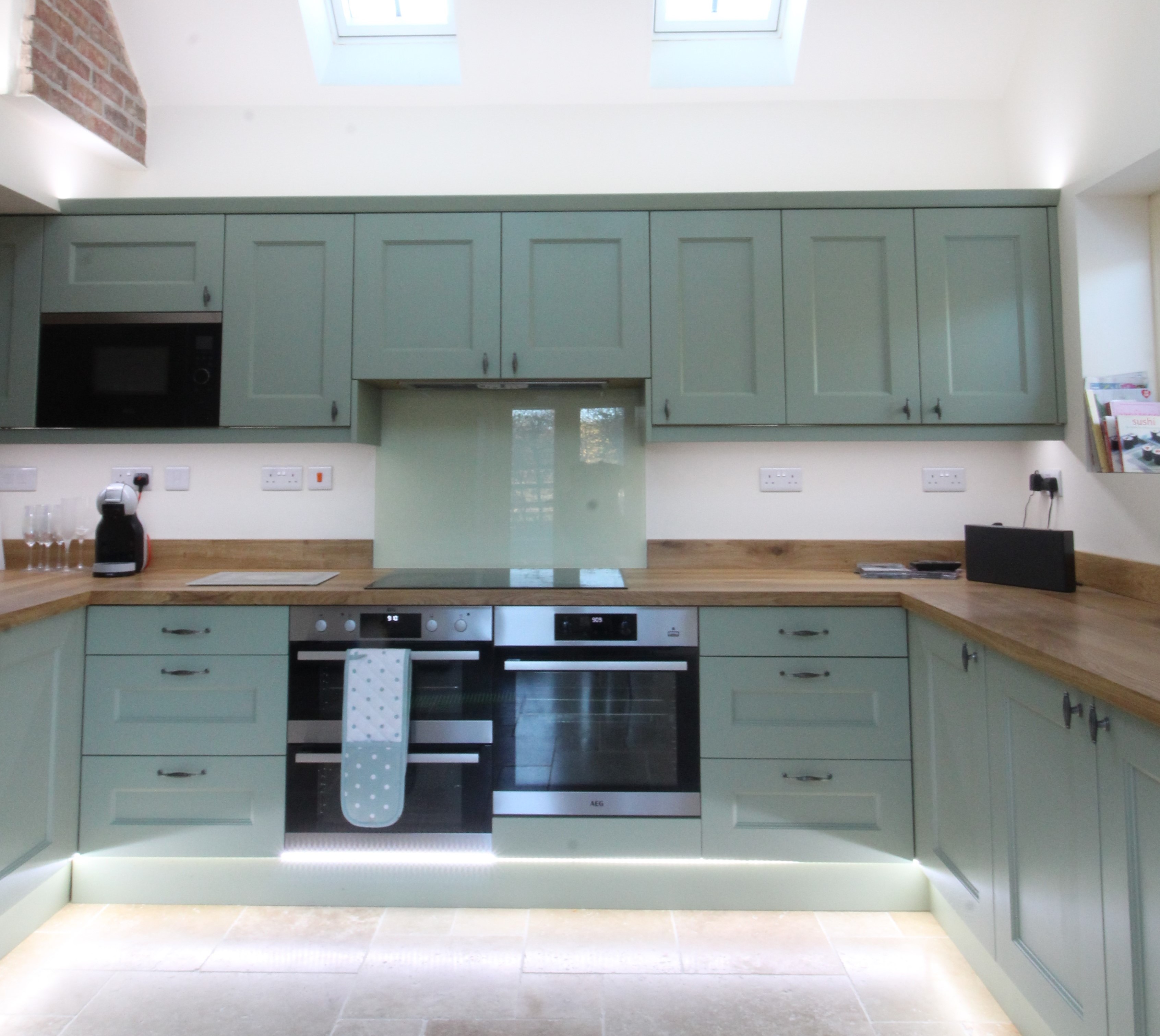 A coastal green alongside lovely oak worktops which gives this kitchen a very welcoming feel.